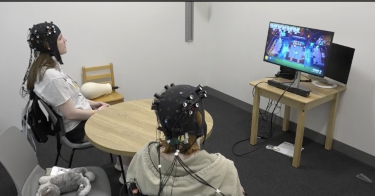 Two participants wearing fNIRS caps while playing a game together